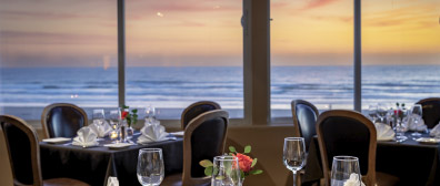 Tables in the restaurant, with sunset over the ocean