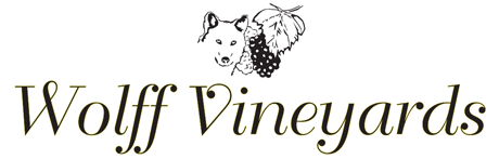 Outline of wolf head with grapes and a grape leaf, with Wolff Vineyards in text below
